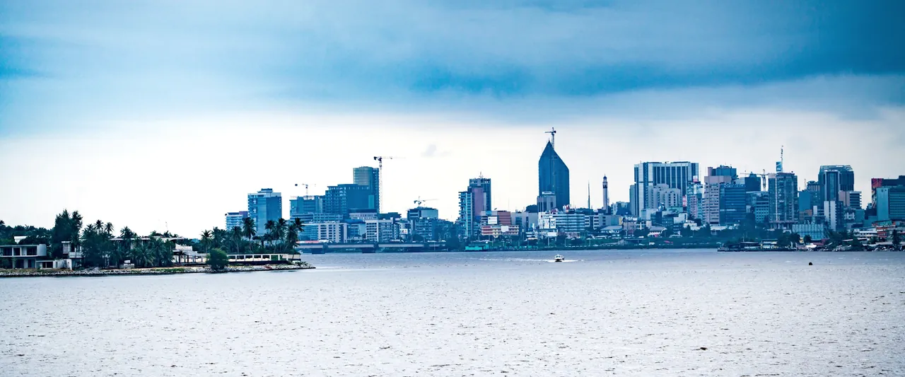 Les tours du Plateau, à Abidjan, vues de l’autre rive de la lagune, sous un ciel chargé.